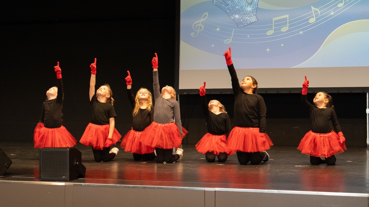 Die Minis in roten Tutus zeigen bei der Show nach oben